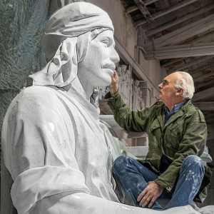 sculptor with oversized marble piece of art