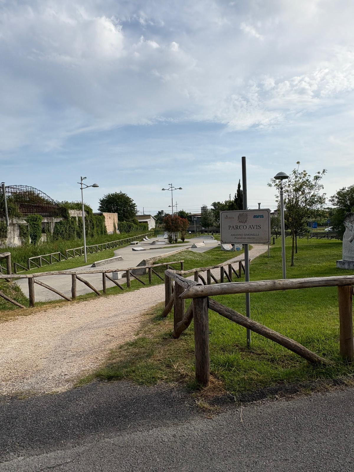 Grassy park with pathways trees and lamp posts