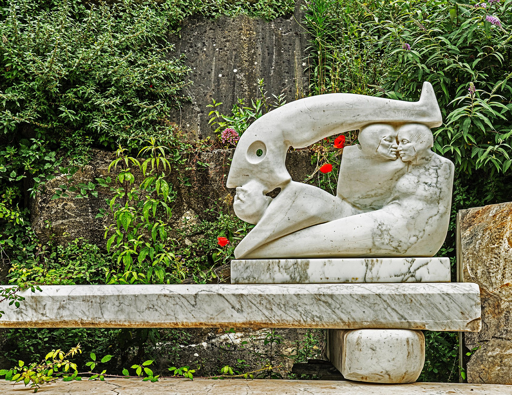 marble abstract figurative sculptures on a large marble bench