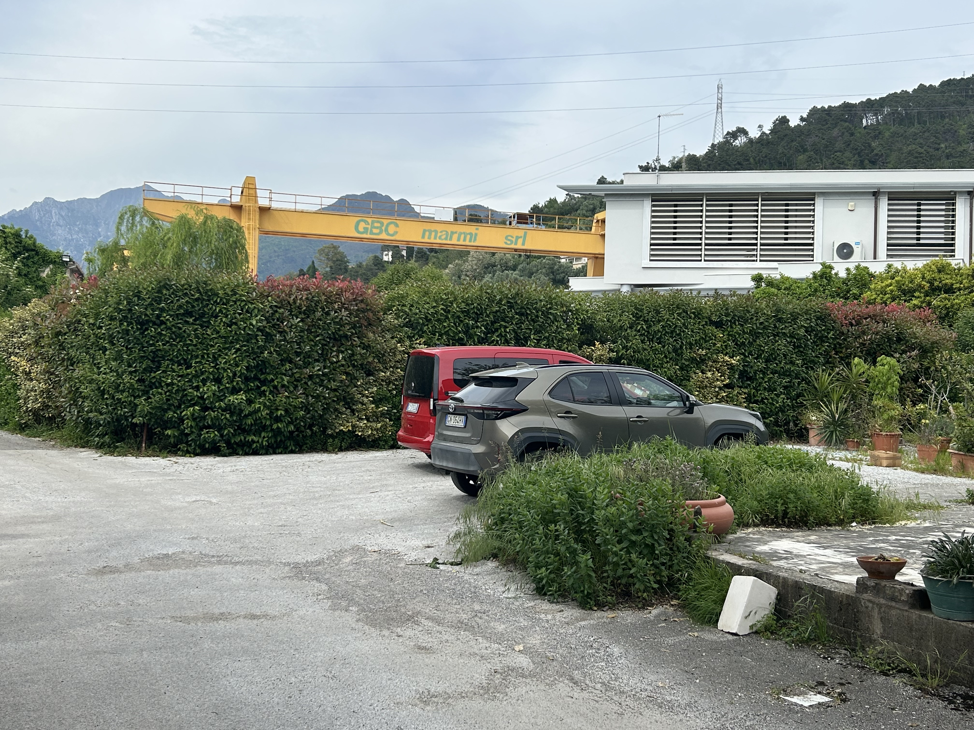 car park with yellow crane and bushes