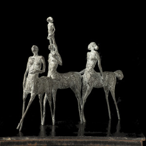 Metal faun sculpture against black background