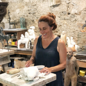 woman smiling while standing in a sculture studio