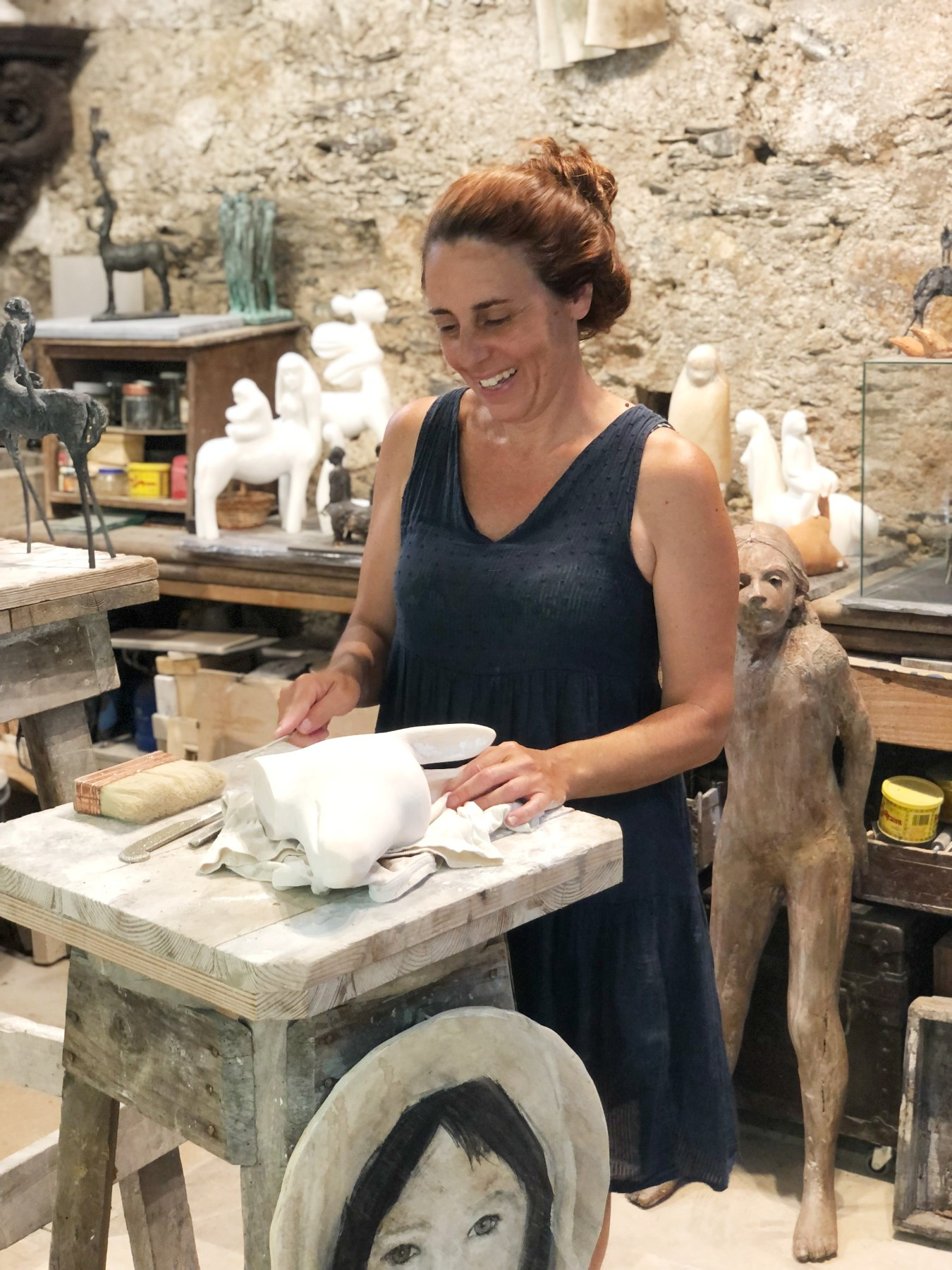 woman smiling while standing in a sculture studio