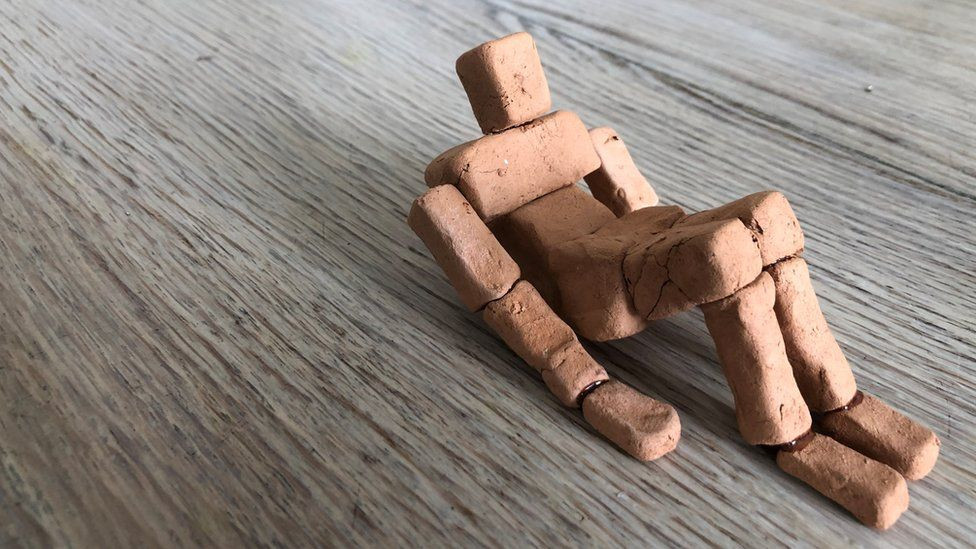 clay model of a reclining figure in blocky shapes