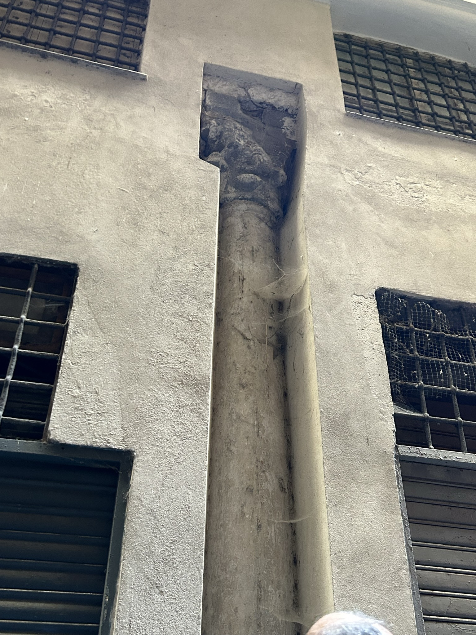 An ancient column surrounded by a more modern building