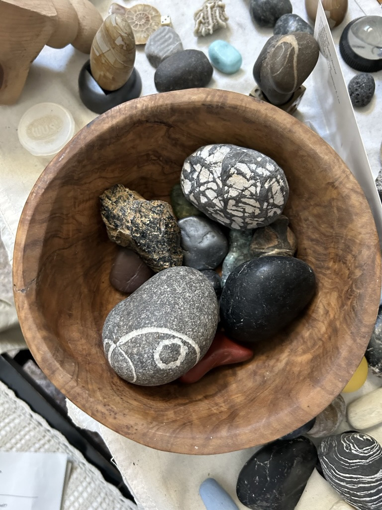 a selection of pebbles in a wooden bowl