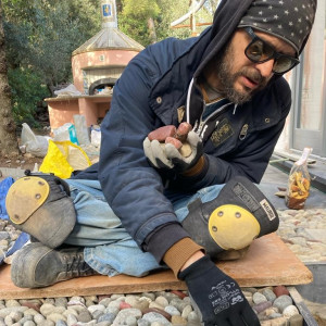 artisan laying stones in to a mosaic