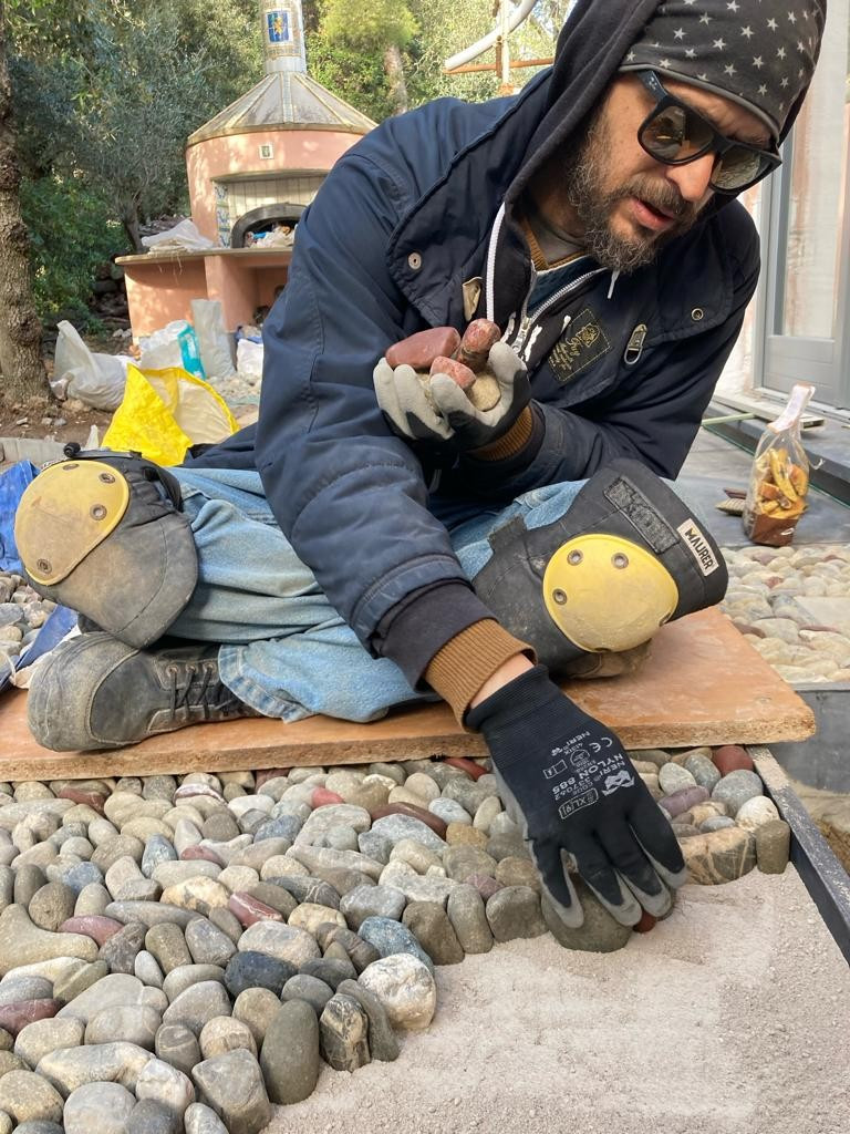 artisan laying stones in to a mosaic