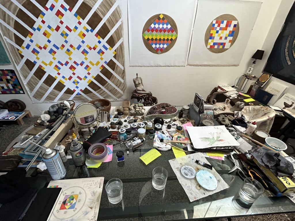 an artist's workbench with pigments, drawings and tools