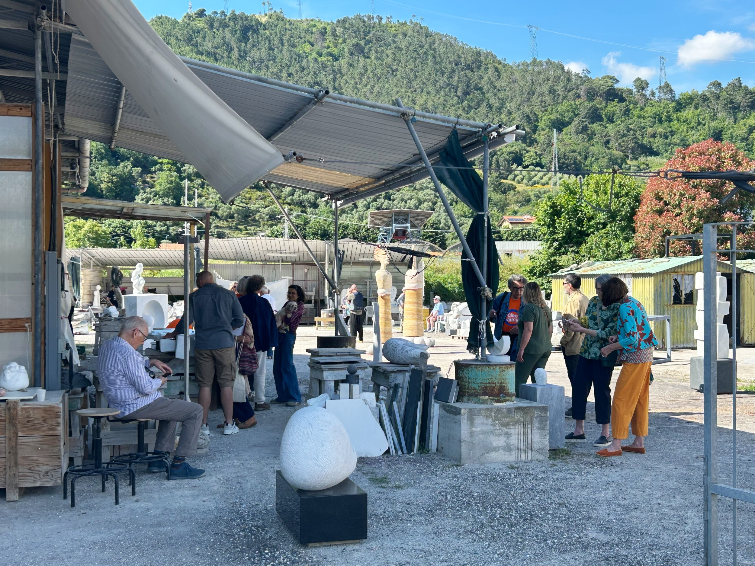group of people outside a sculptor's studio in the summer