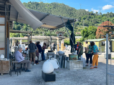 group of people outside a sculptor's studio in the summer