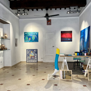 inside a painters studio with marble floors, white walls and playful abstract art work.