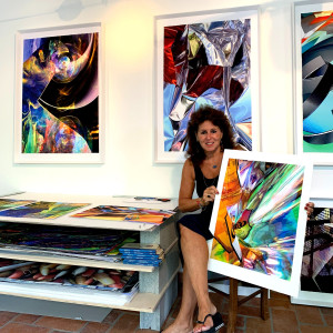 seated woman holding colourful artwork.