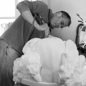 black and white photo of man sculpting white marble.