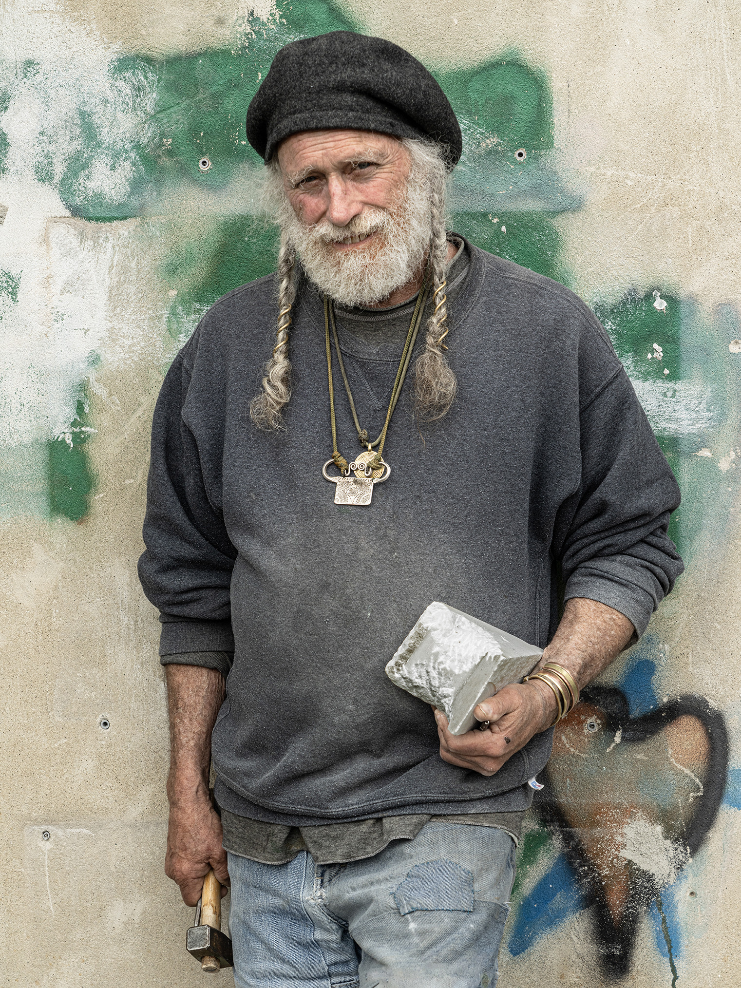 Man holding block of marble and hammer