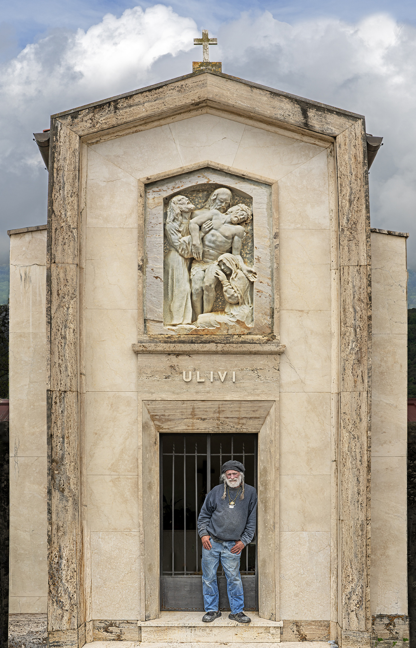man standing in front of cemetery sculpture