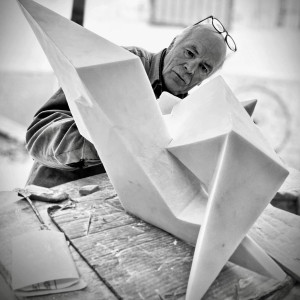 black and white photo of older man working on a marble sculpture