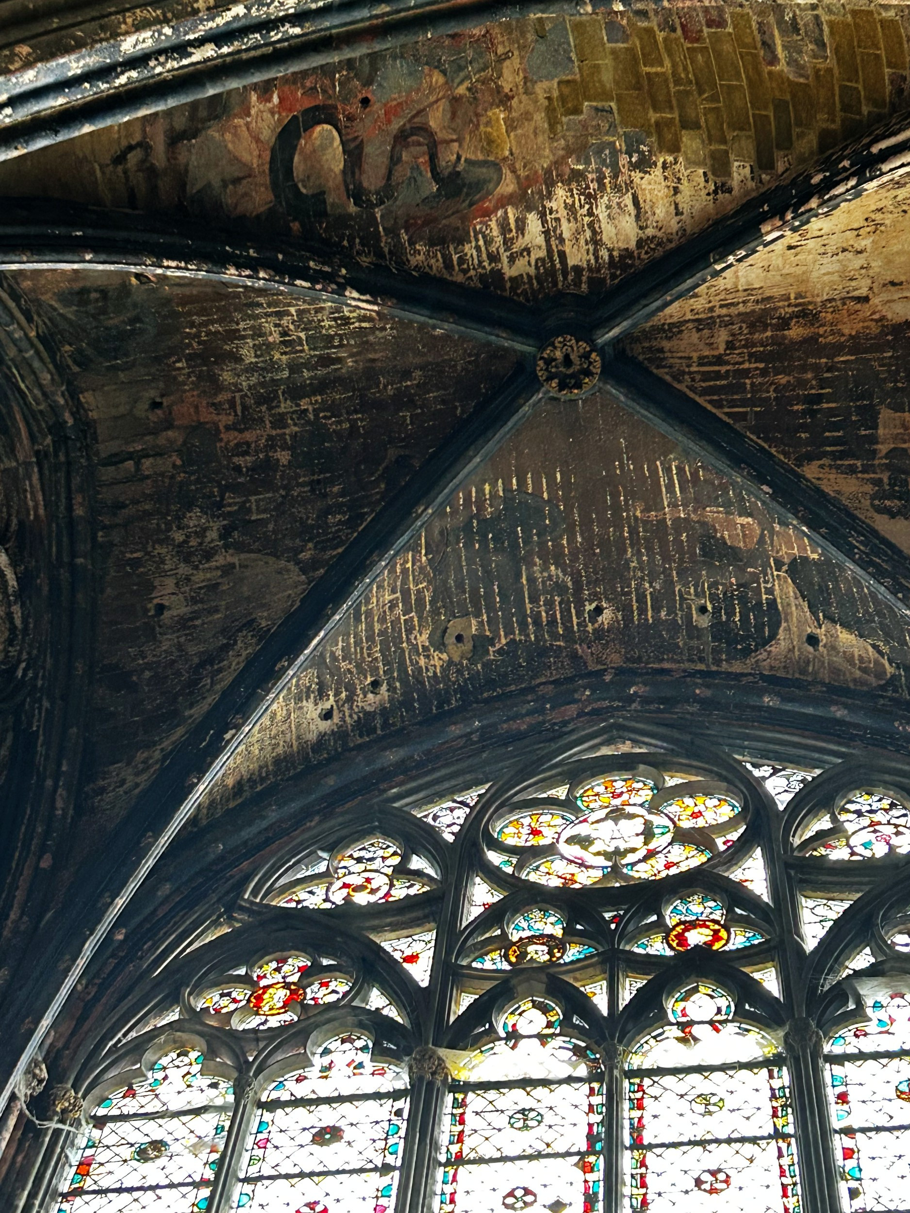 Gothic arched ceiling with fresco and stained glass window