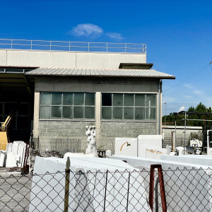 Outside of artists studio with slabs of marble and sculptures in the entrance.