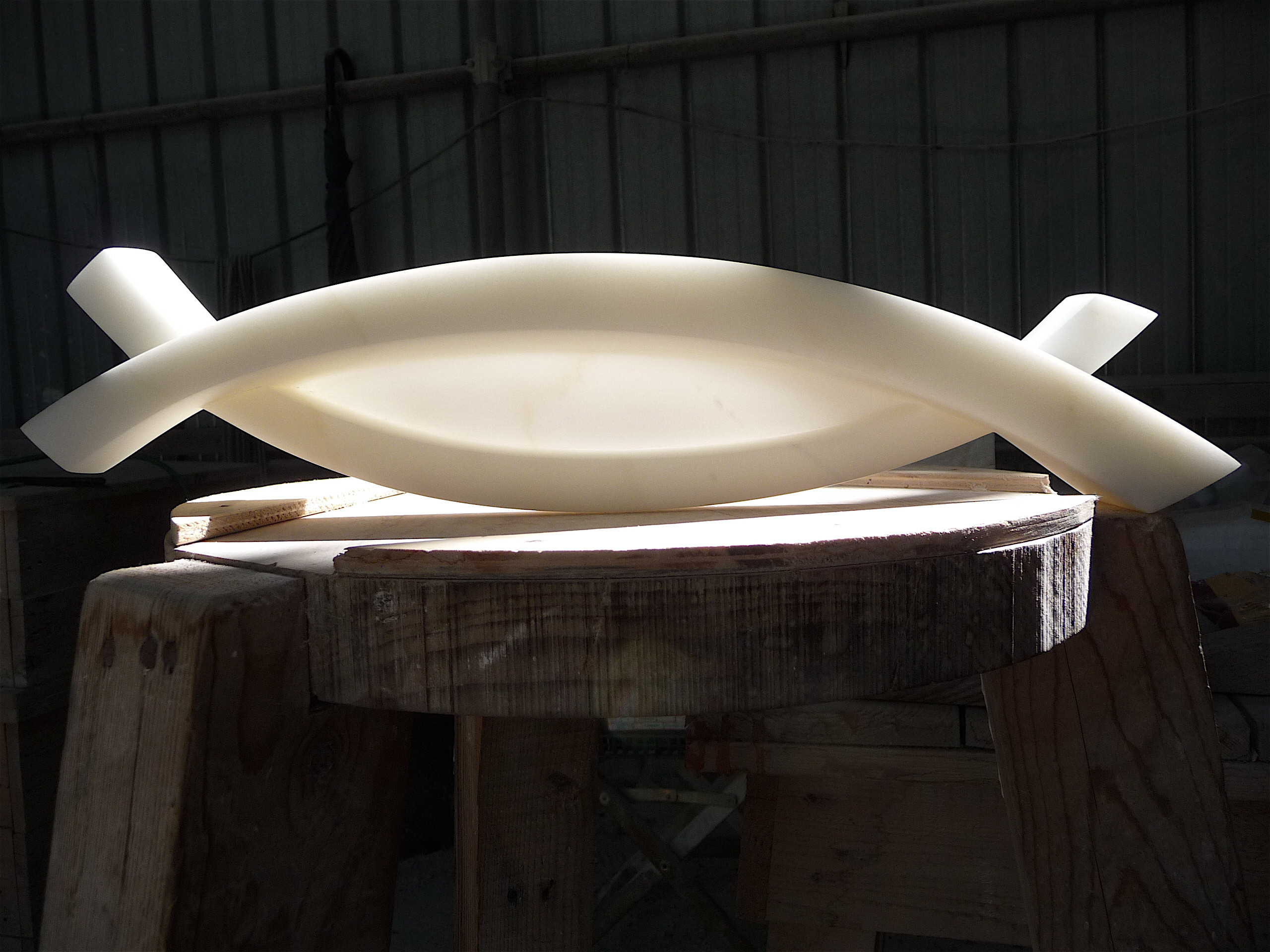 Abstract white marble sculpture on wooden plinth