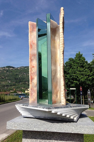 mixed material sculpture resembling a giant book on a geometric marble plinth