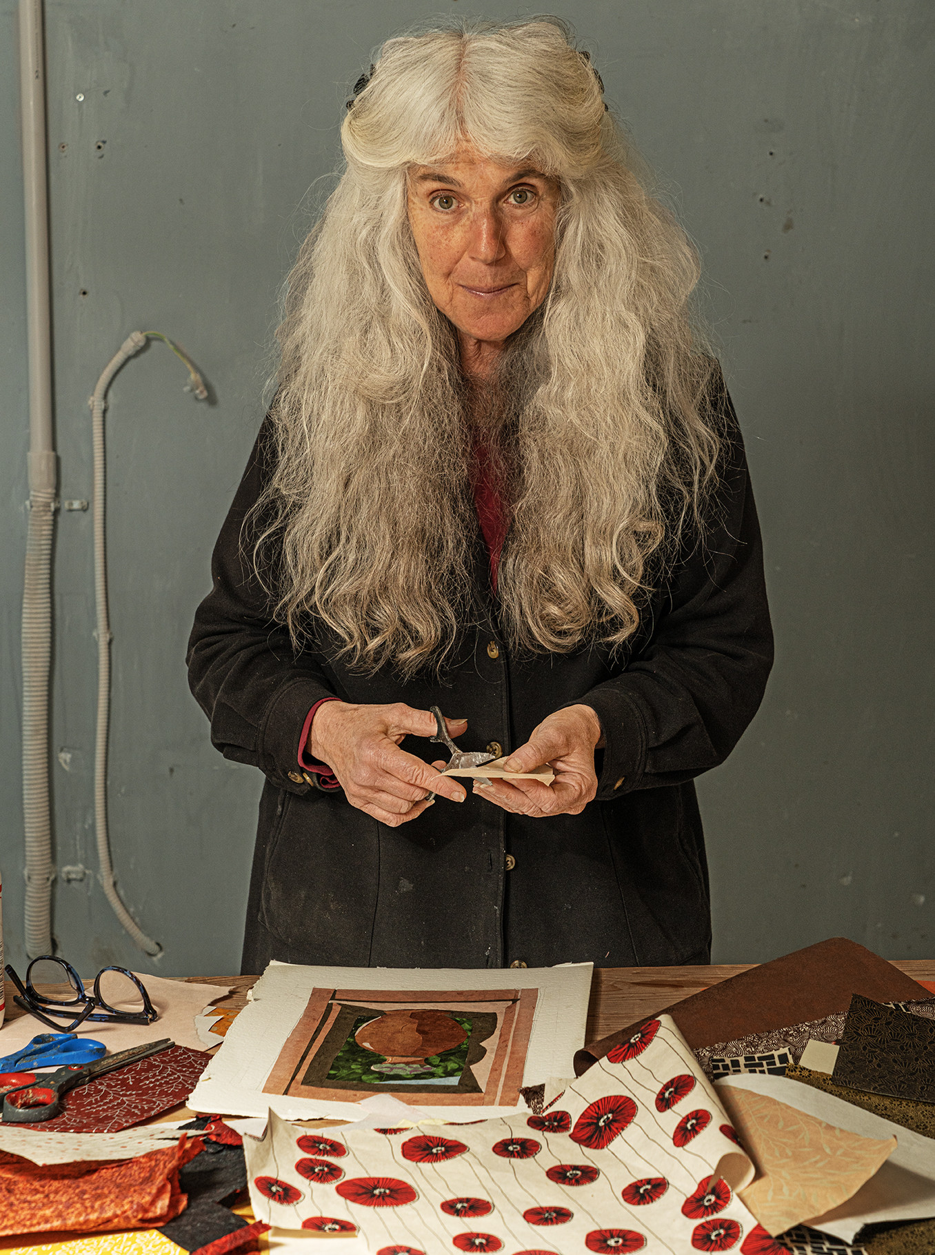 Female collage artist standing at work table