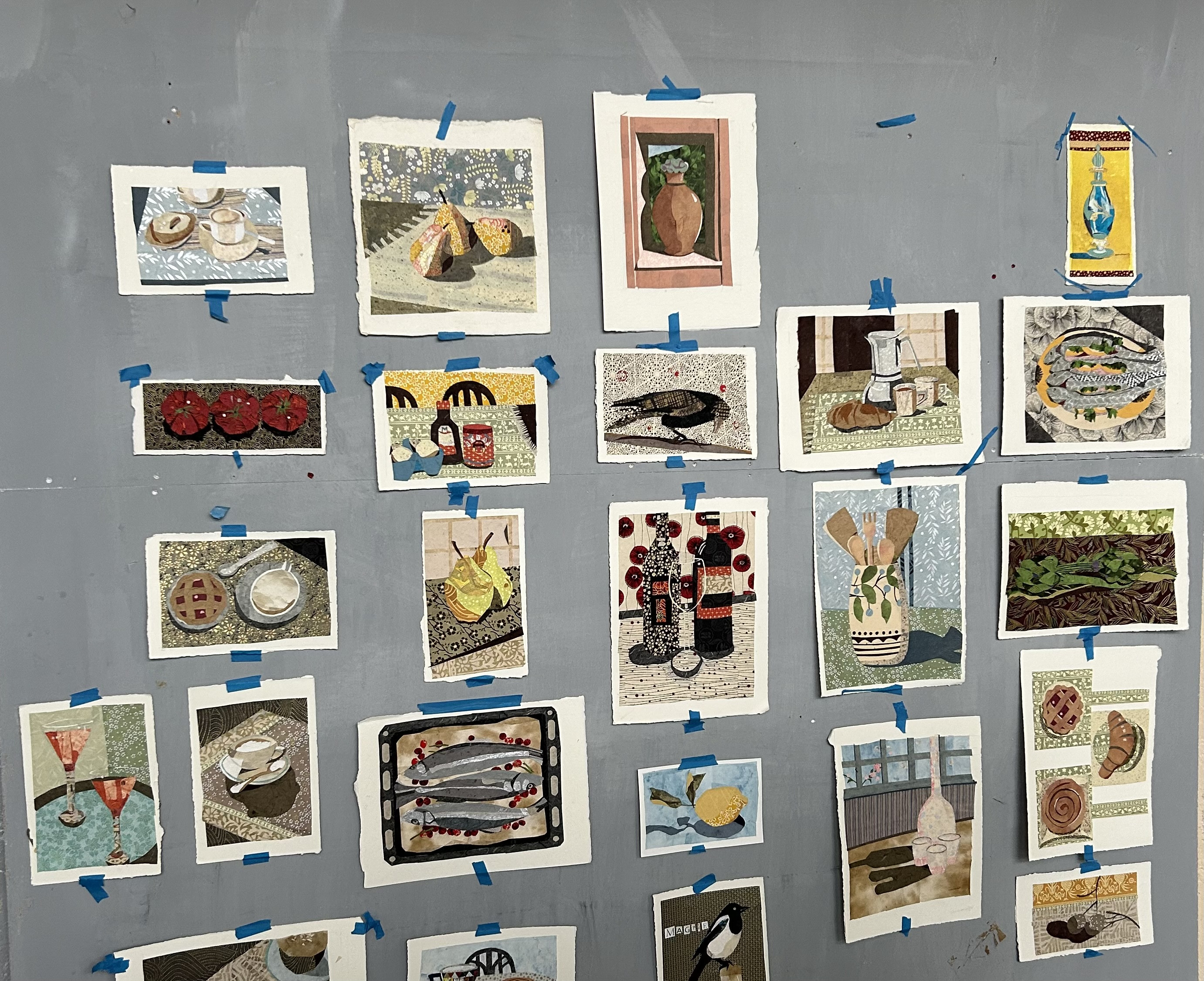selection of collage artwork taped to a wall