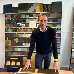 smiling man standing with a selection of sheet metal samples