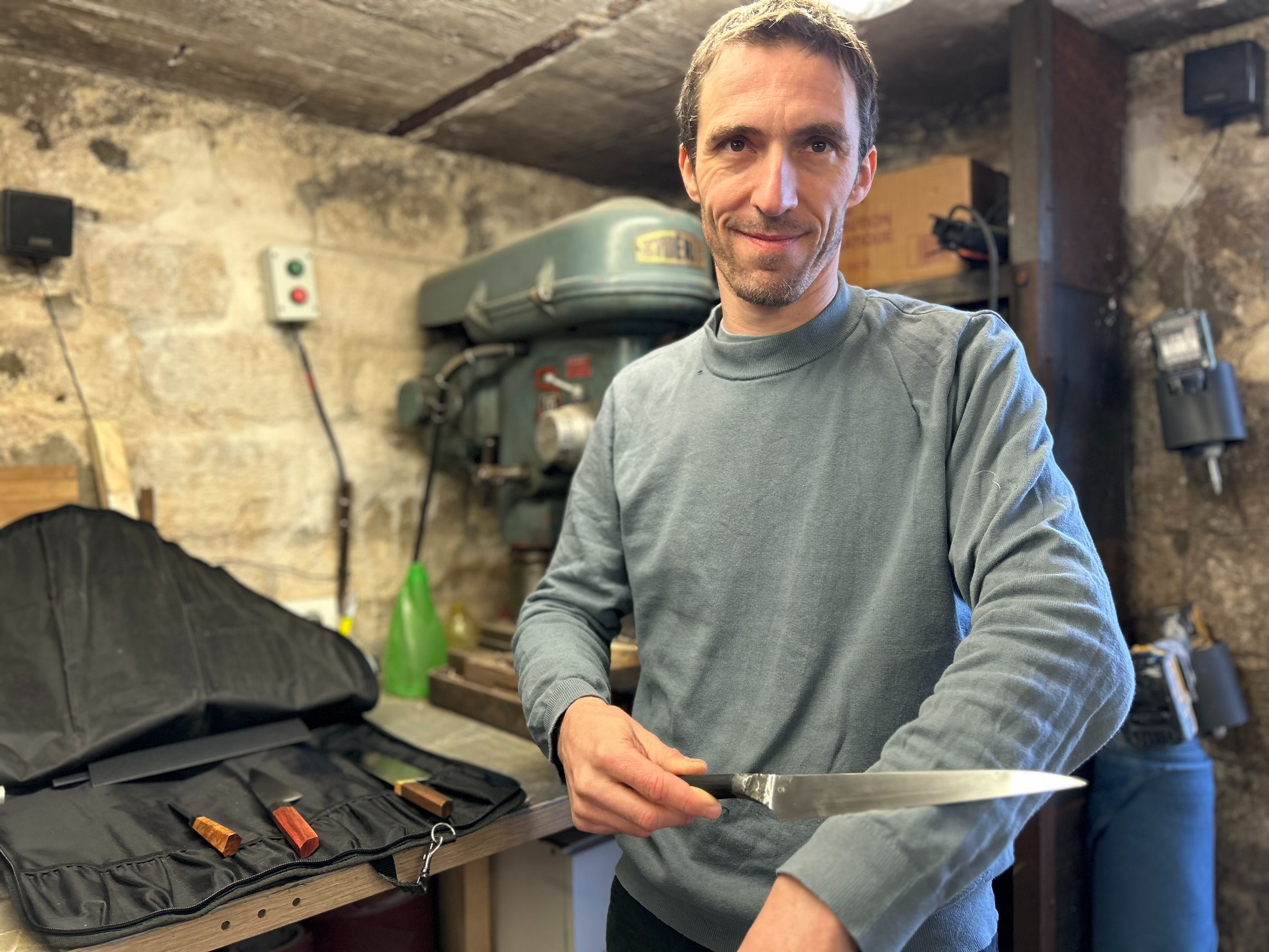 man in workshop holding knife