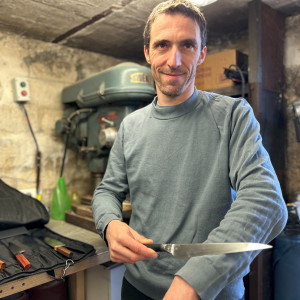 man in workshop holding knife
